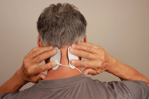 istock Man using a Electro Therapy Massager or Tens Unit on the back of his neck 2158093208
