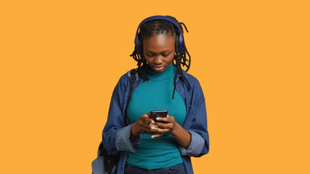 istock Woman talks with friends during videocall using phone and headphones 2158094897