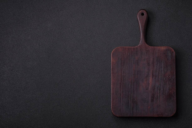 istock Empty wooden cutting board on dark textured concrete background 2158097599