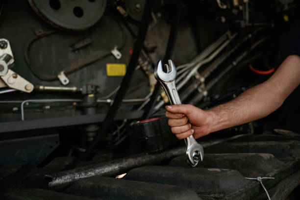 istock Close up view. Mechanic's hand fixing machinery with wrench in workshop 2158098156