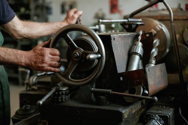 istock Close-up of worker's hands operating industrial machinery in workshop 2158098214