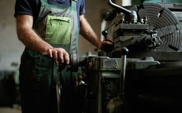 istock Side view. Close-up of worker's hands operating industrial machinery in workshop 2158098247