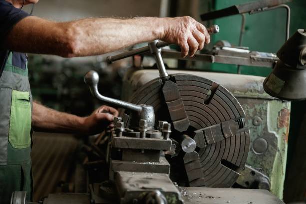 istock Side view. Close-up of worker's hands operating industrial machinery in workshop 2158098251