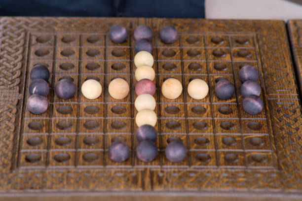 istock Mill is a classic two-player board game. Each player has nine pieces, aiming to form lines of three, called mills. Forming a mill lets a player remove an opponent's piece 2158098355