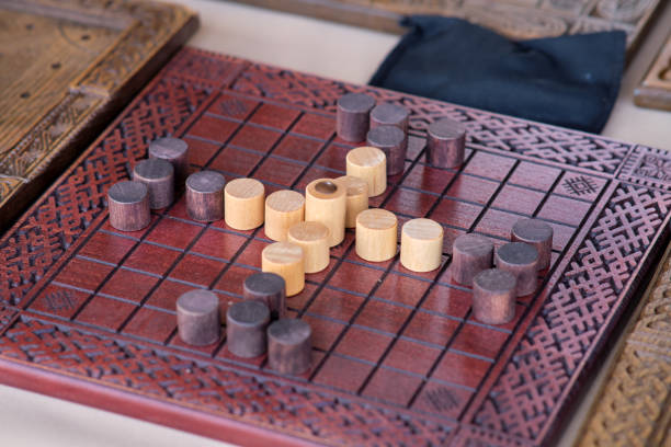 istock Morris involves two players trying to create rows of three pieces called 'mills.' Players place and move their pieces to form mills and capture opponents' pieces 2158098356