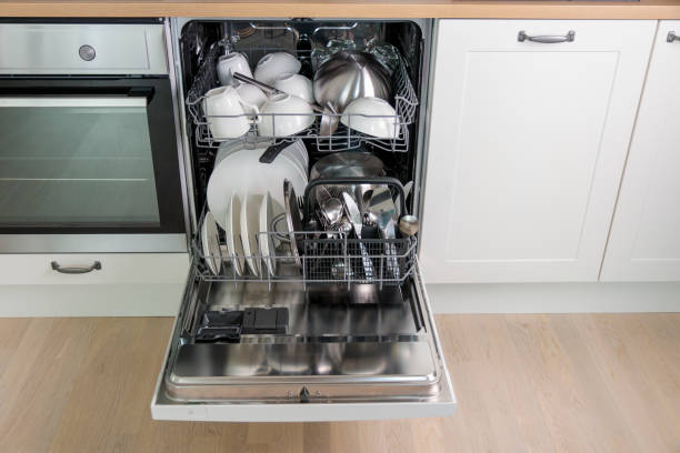 istock Time-saving technology. Open built-in dishwasher. Kitchen with integrated appliances. Clean plates and dishes in the dishwasher 2158100130