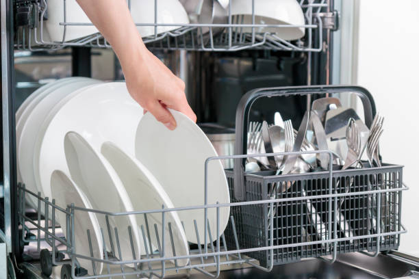 istock Female hand unloading dishwasher with tableware. Kitchen appliances, lifestyle view. Woman takes a plate from the dishwasher. Concept of modern technologies in the kitchen 2158100241