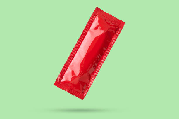istock Blank red foil tomato ketchup sauce sachet package float on green background 2158103078