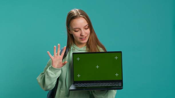 istock Smiling woman presenting laptop with green screen display 2158103955