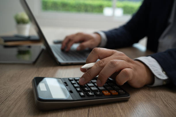 istock calculate Accounting Business man using calculator Business man using calculator Close-up 2158106338