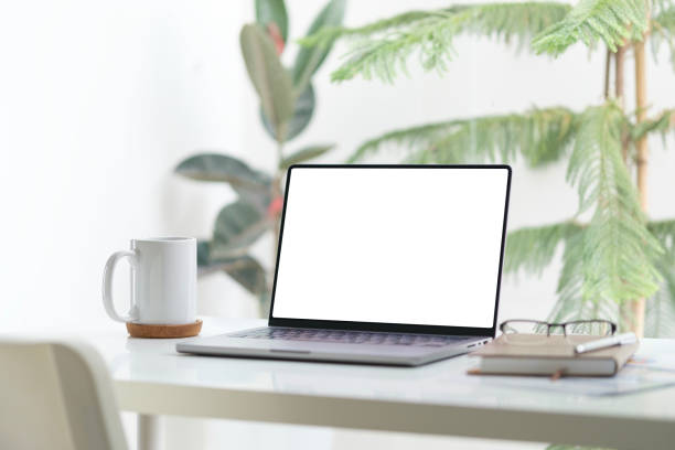 istock Laptop, coffee cup and notebook on white table. Empty screen for your advertise design. 2158106626