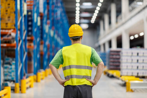 istock Back view of warehouseman standing with hands on hips and planning work. 2158110713