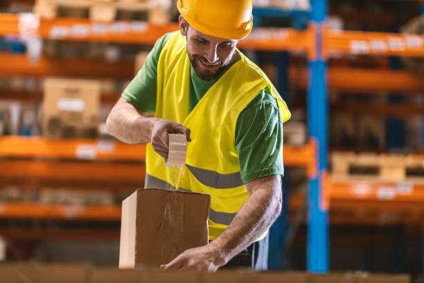 istock A delivery center worker is packing box with goods. 2158110826