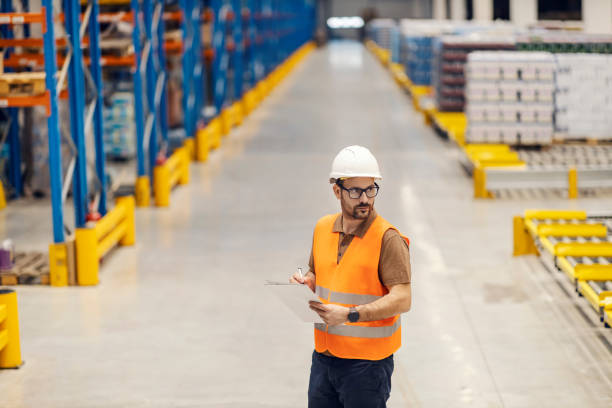 istock A warehouse manager is standing in facility and writing down on papers. 2158111382