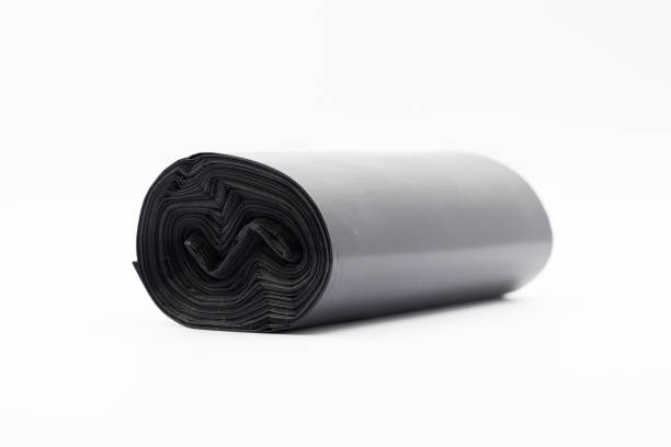 istock Black plastic garbage bags on white background, Roll of garbage bags on white background 2158111558