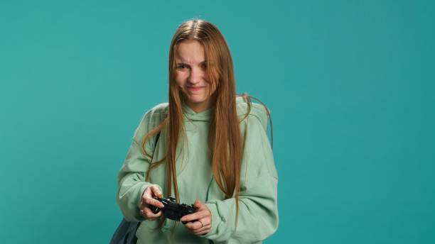 istock Young girl spamming controller buttons, disappointed after game over 2158111993