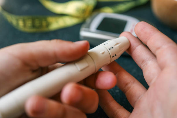 istock Man measuring blood sugar, close-up 2158112751