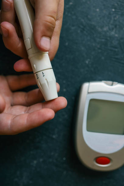 istock Man measuring blood sugar, close-up 2158112753