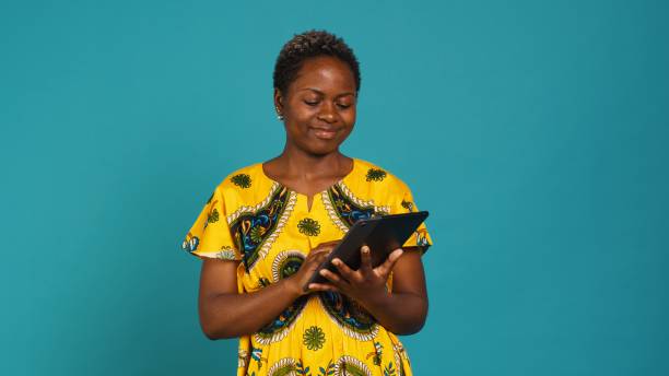 istock Smiling happy person checking internet websites on her tablet in studio 2158113426