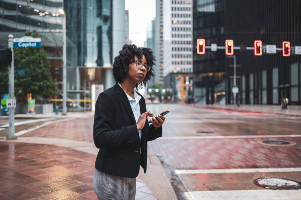 istock Businesswoman using mobile phone in city during commute 2158115411