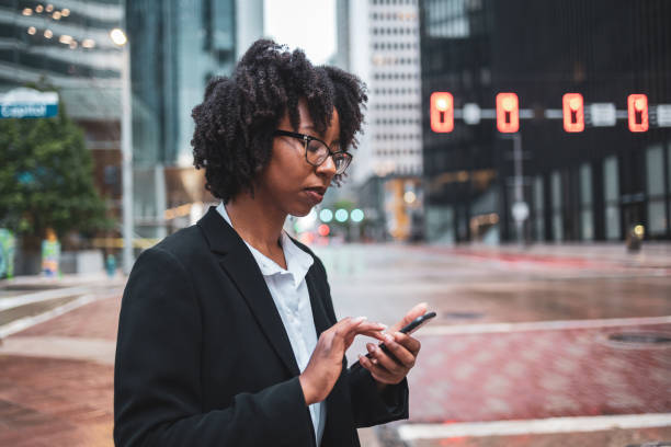 istock Businesswoman using mobile phone in city during commute 2158115469