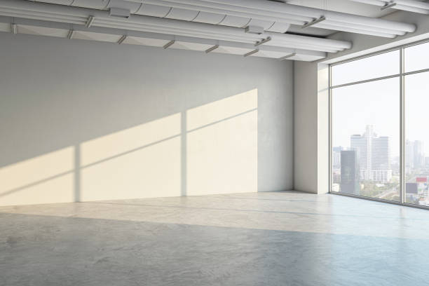 istock Empty modern room with a large window, concrete floor, and a city view, bathed in natural sunlight, concept of space and design. 3D Rendering 2158116745