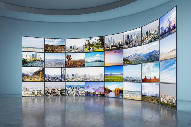 istock Multiple screens displaying diverse landscapes in a room with reflective floor, curved blue walls, and modern gallery concept. 3D Rendering 2158116755