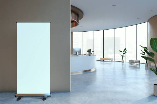 istock A blank rollup banner in a modern office interior with large windows, grey wall, and blue floor, concept of advertising. 3D Rendering 2158117358