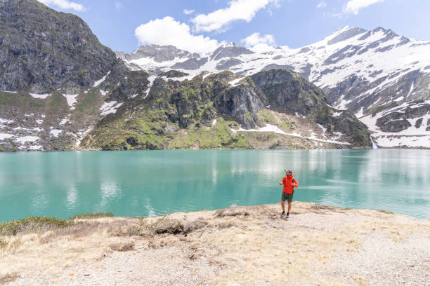 istock Man Walking by Tranquil Mountain Lake 2158117703