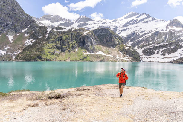 istock Man Hiking by Turquoise Mountain Lake 2158118154