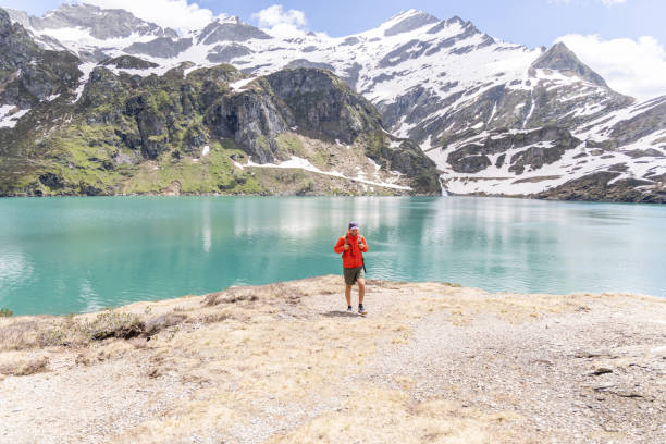 istock Man Hiking by Turquoise Mountain Lake 2158118162
