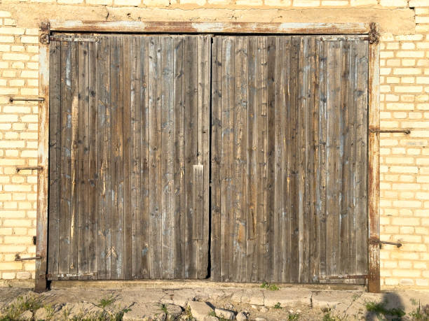 Closed wooden door with X pattern on outside of weathered building