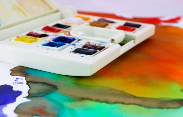 istock Case with watercolor pills of different colors on abstract background 2158120418