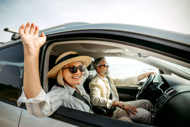 istock Senior woman leaning through car window while enjoying ride with her husband 2158120444