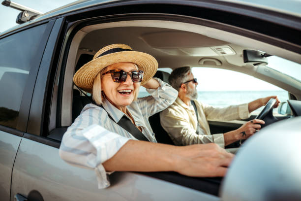 istock Senior woman leaning through car window while enjoying ride with her husband 2158120453