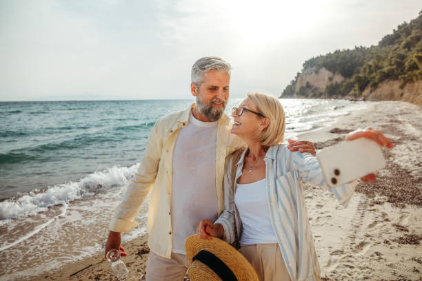 istock Mature couple taking a selfie while enjoying day on a beach 2158121105