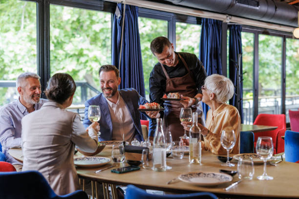 istock Group of friends enjoying lunch at a modern restaurant 2158122395