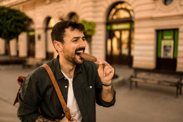 istock Happy young man eating Ice Cream while exploring the city. 2158122615