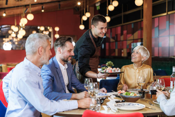 istock Group of friends enjoying dinner at a stylish restaurant 2158122625