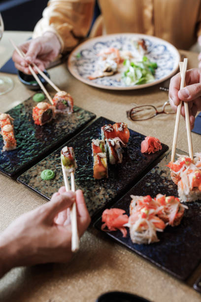 istock People enjoying a sushi meal with chopsticks at a restaurant 2158122643