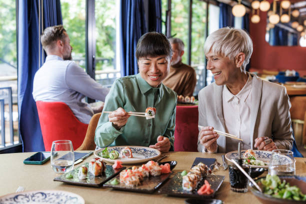 istock Two women enjoying sushi together in a modern restaurant 2158122692