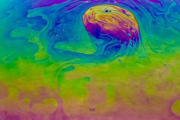 Close up, macro shot of a rainbow, multi colored soap bubble with yellow, purple, pink, blue and green colors.