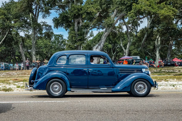 There is an old blue car on the street