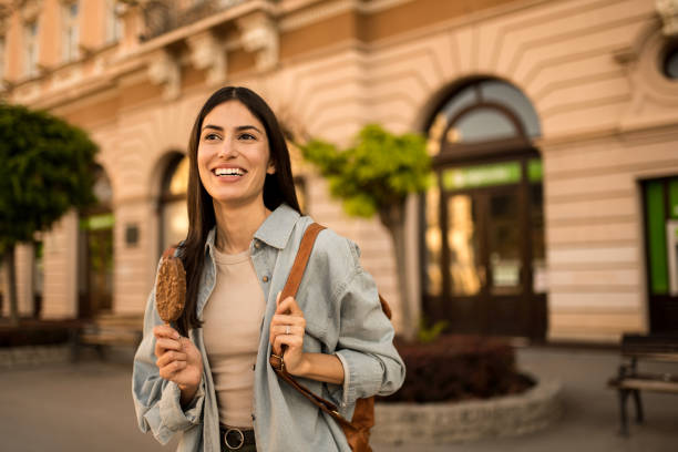 istock Happy young woman eating Ice Cream while exploring the city. 2158123108