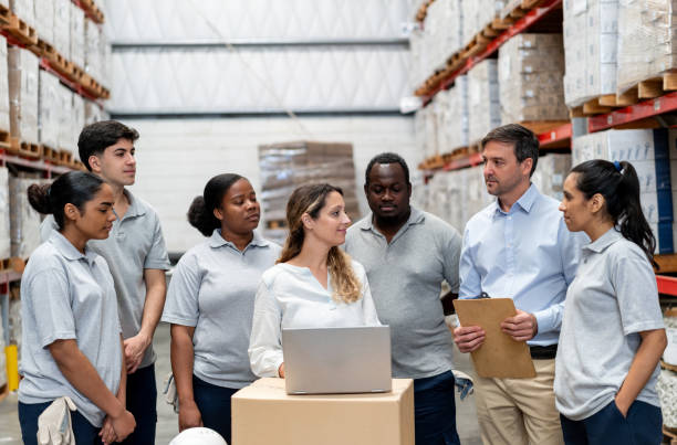 istock Boss talking to a group of warehouse workers in a staff meeting 2158124251
