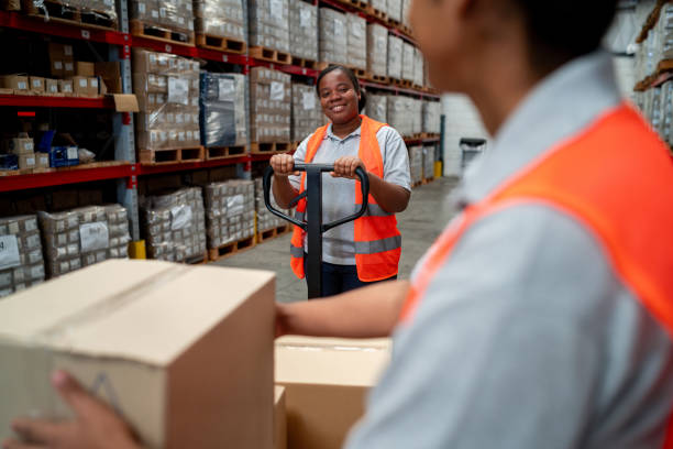 istock Team of warehouse workers moving boxes at a warehouse 2158124298