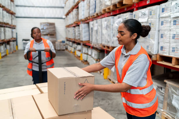 istock Women working at a warehouse moving boxes 2158124305