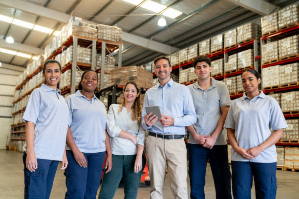 istock Team of warehouse workers smiling at the camera 2158124318
