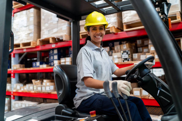 istock Female employee driving a forklift at a distribution warehouse 2158124346