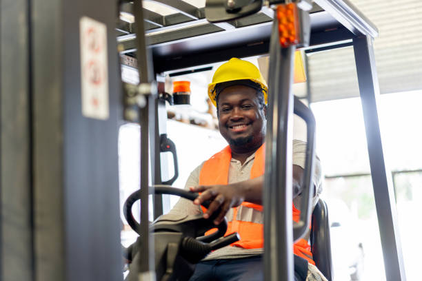 istock Warehouse worker driving a forklift at work and smiling 2158124360